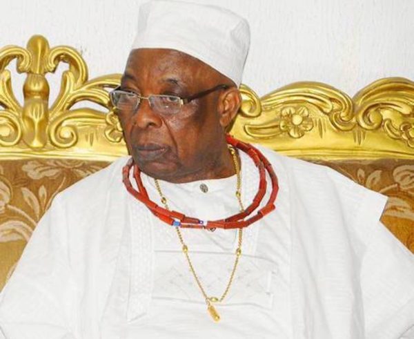 Oba Aromolaran II seated in white attire with a white cap and coral beads