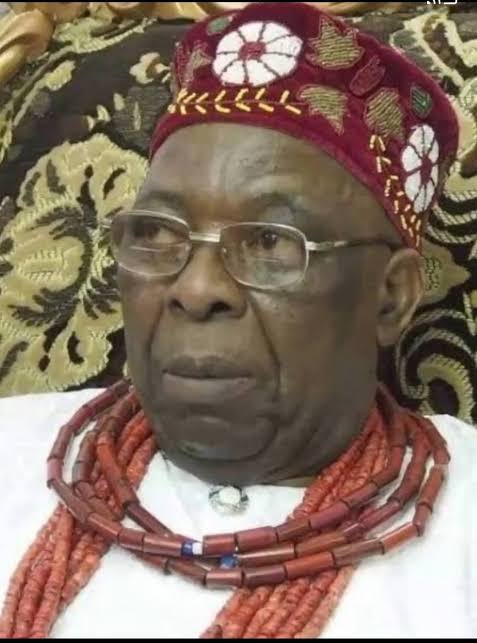 Close portrait of Oba Aromolaran II wearing glasses, coral beads and a patterned cap